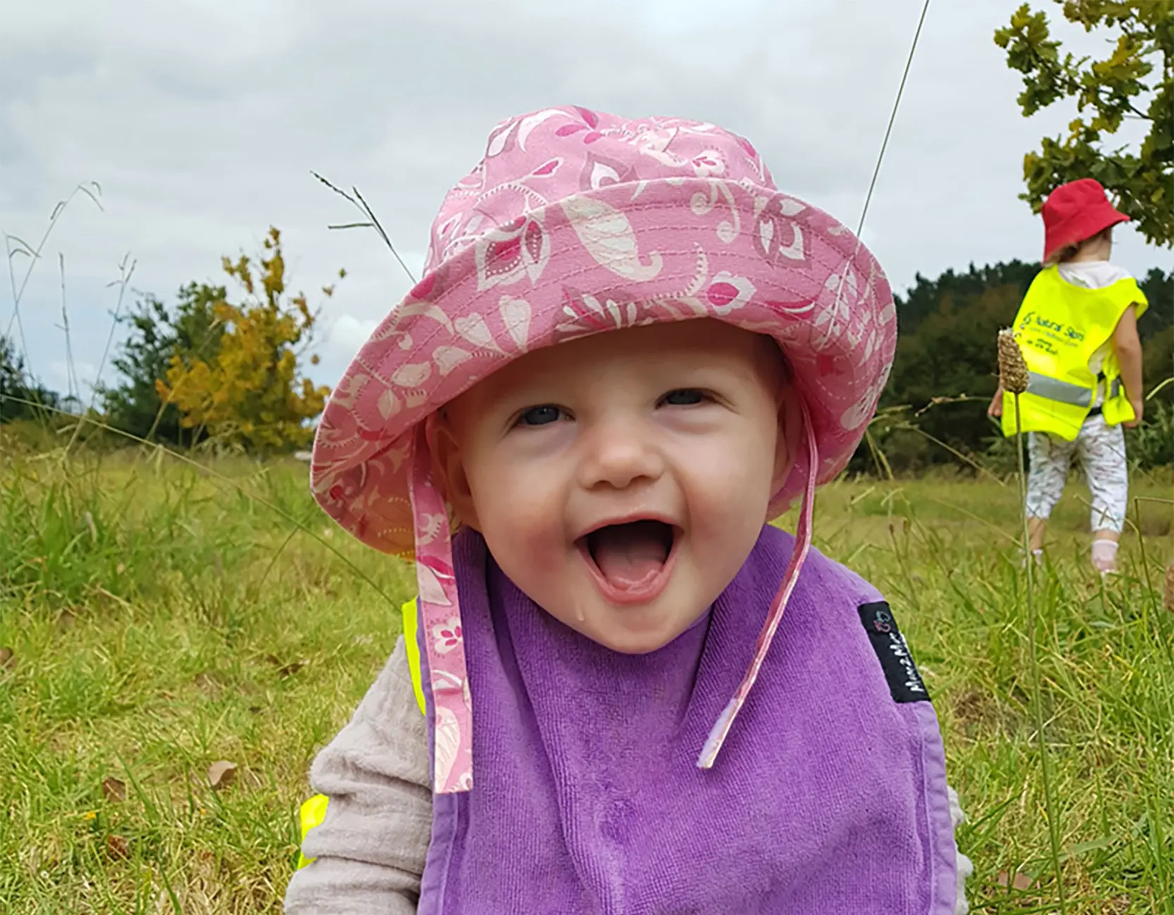 happy little girl outside with pink sunhat