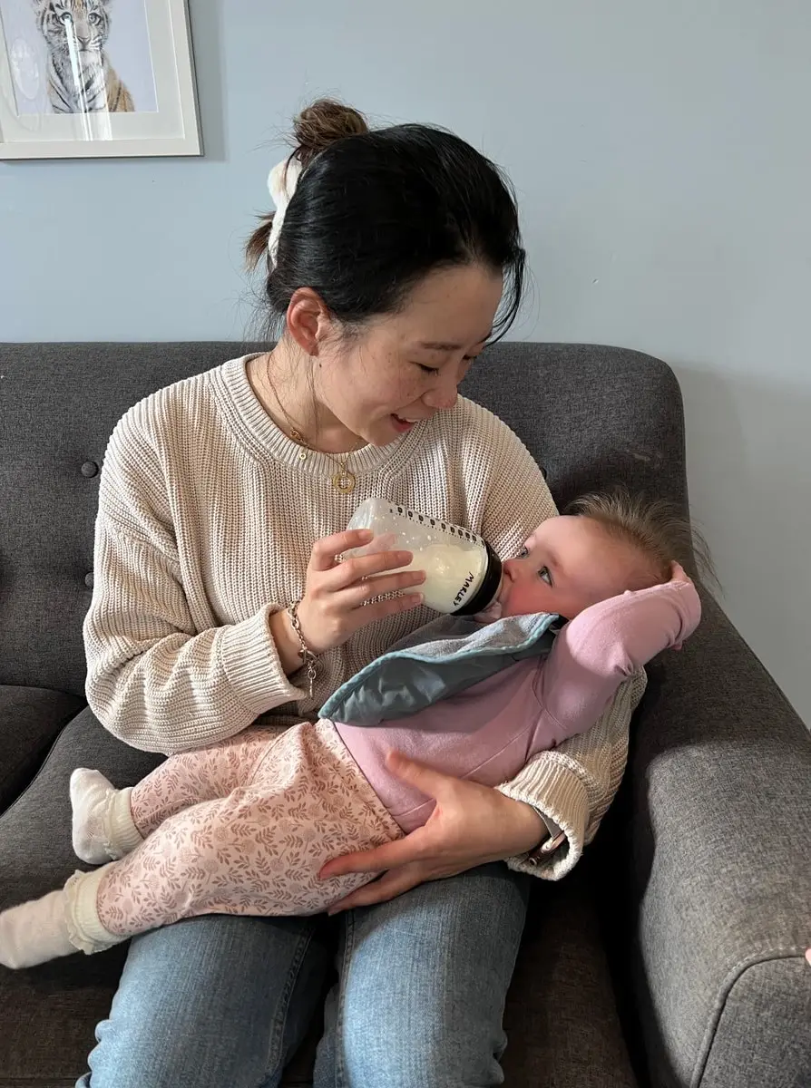 teacher feeding bottle to infant