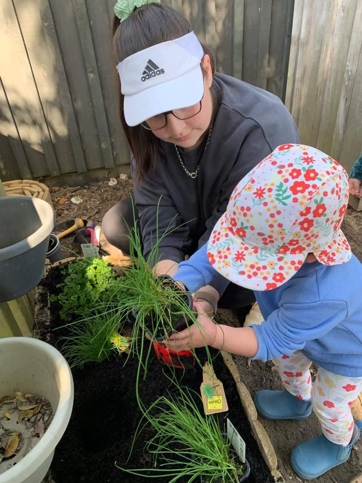 toddler helping gardening at Piccolo room